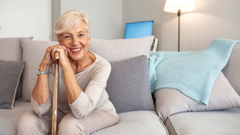 Lady with dentures sitting on couch and smiling